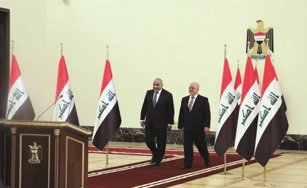 رئيس الوزراء العراقي الجديد عادل عبدالمهدي وسلفه حيدر العبادي خلال مراسم التسليم والتسلم امس	(رويترز) ﻿