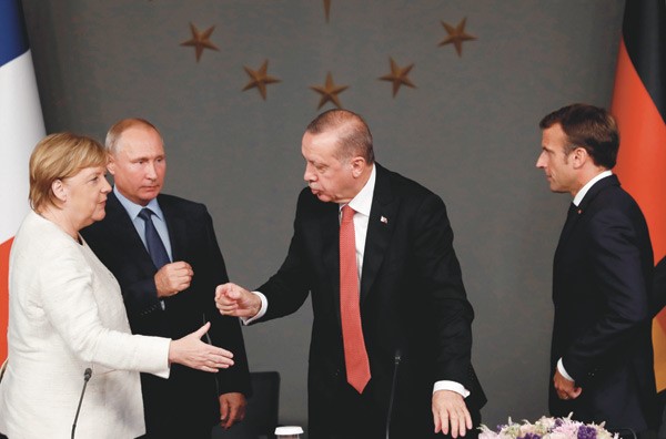 المستشارة انجيلا ميركل تصافح الرئيس رجب طيب اردوغان بحضور الرئيسين فلاديمير بوتين وايمانويل ماكرون في ختام قمة اسطنبول                (رويترز)