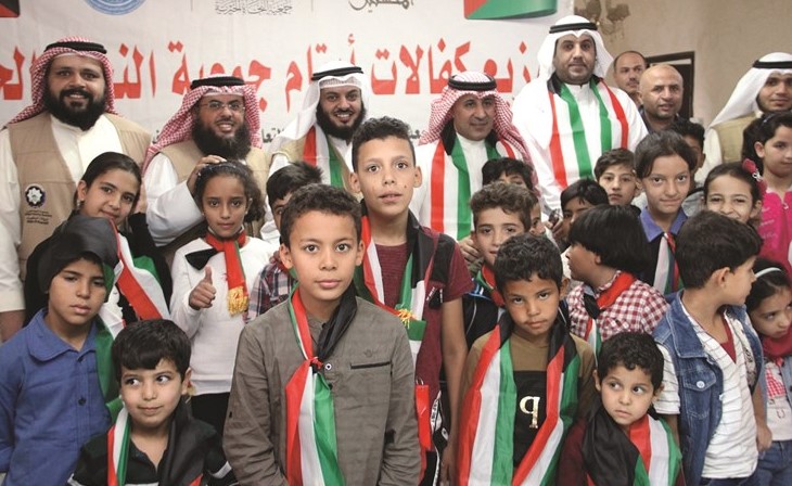 سفيرنا لدى الأردن عزيز الديحاني مشاركا قيادات جمعية النجاة في توزيع كفالة الأيتام﻿