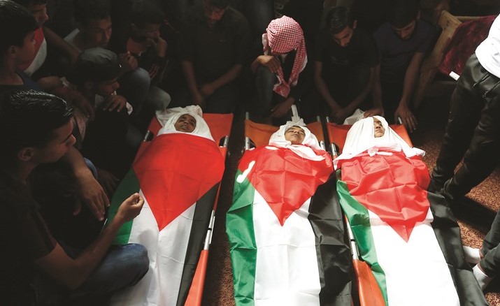 فلسطينيون يشيعون ثلاثة أطفال استشهدوا برصاص الاحتلال أول من أمس	 (أ.ف.پ)﻿