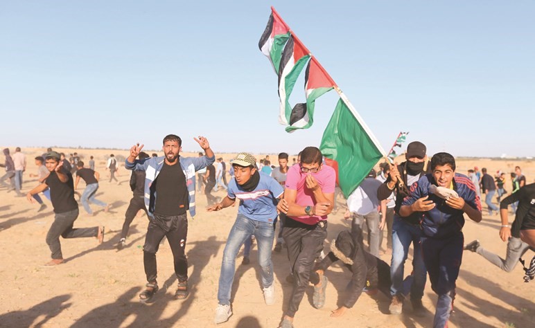 فلسطينيون يواجهون وابل الرصاص خلال جمعة سنسقط الوعد المشؤوم على حدود غزة أمس	(رويترز) ﻿