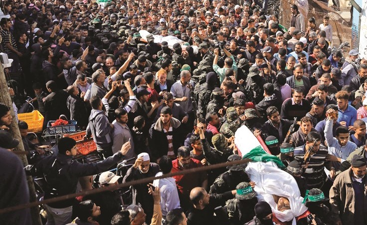 فلسطينيون يشيعون ثلاثة من الفلسطينيين السبعة الذين استشهدوا في غزة أمس 	(أ.ف.پ)﻿