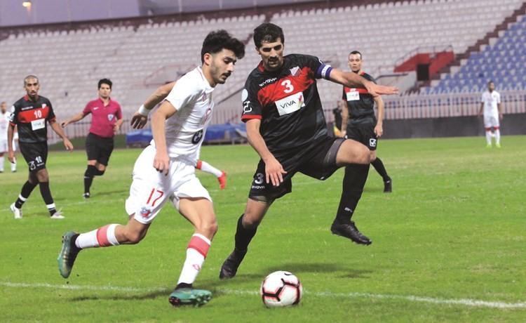 حسين إسماعيل يحاول إيقاف لاعب الكويت حسين الحربي (المركز الاعلامي بنادي الكويت) ﻿