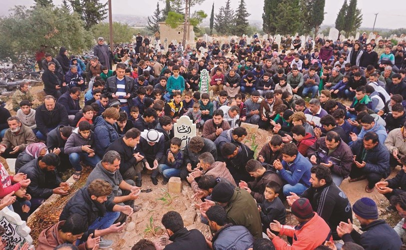 مشيعون يحضرون جنازة رائد الفارس وحمود جنيد في قرية كفرنبل بإدلب أمس- (أ.ف.پ)﻿