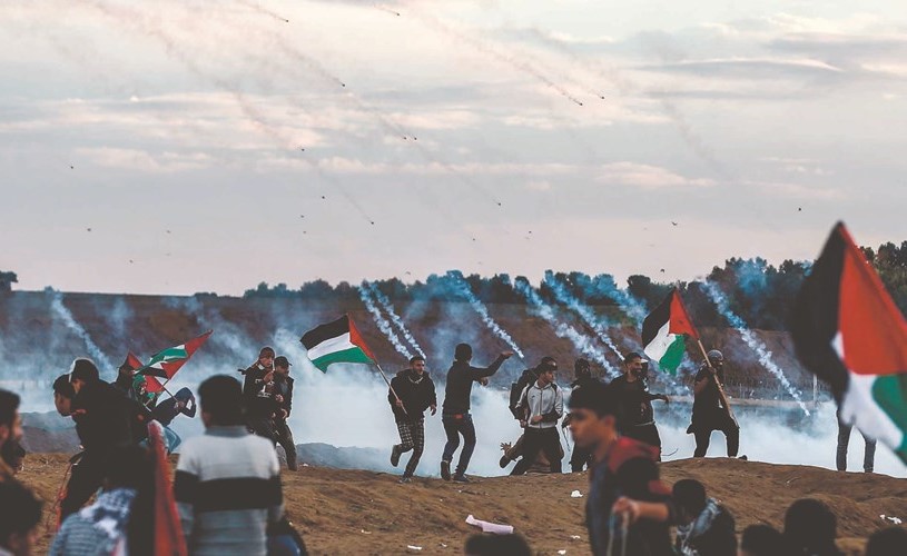 فلسطينيون يتصدون لقنابل الغاز المسيل للدموع التي أطلقتها قوات الاحتلال في غزة (أ.ف.پ)﻿