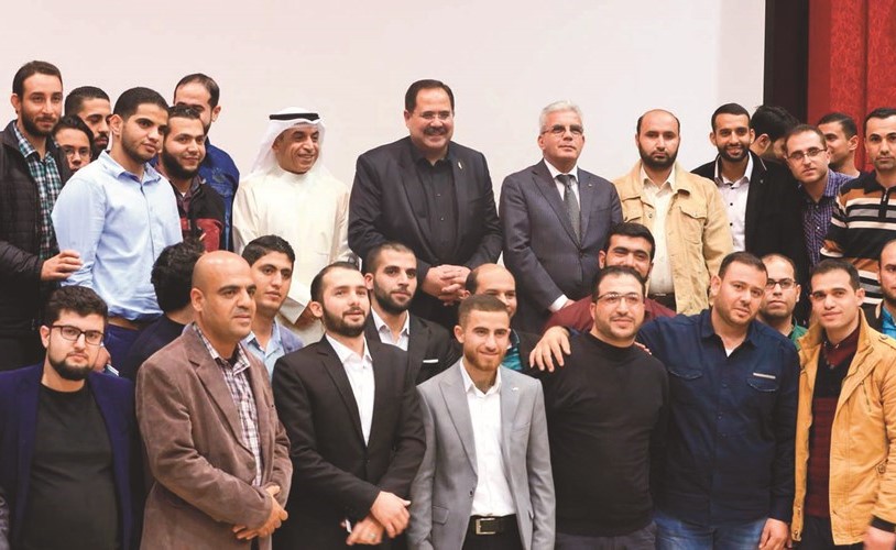 الوزير د.حامد العازمي ونظيره الفلسطيني يتوسطان المعلمين الفلسطينيين خلال اللقاء﻿
