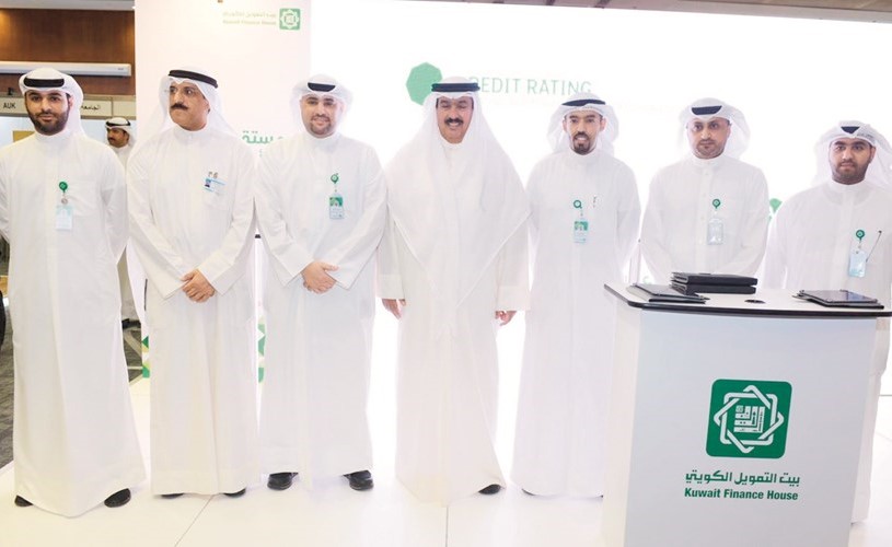 د.علي المضف مع مسؤولي بيتك في جناحهم بالمعرض ﻿