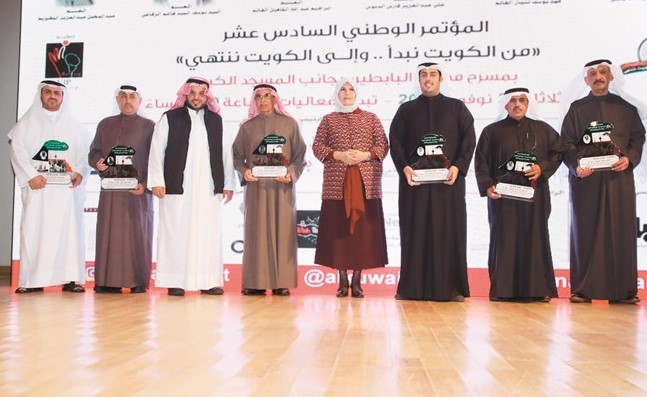 يوسف الياسين وكوثر الجوعان يتوسطان ذوي المكرمين خلال الاحتفال﻿