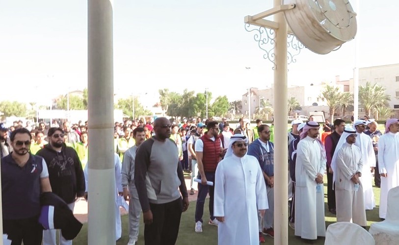 مدير المدرسة والمديرون المساعدون ولفيف من المعلمين وأولياء الأمور والطلاب خلال تحية العلم في بداية المهرجان﻿