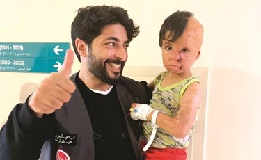د.عبدالعزيز الرشيد مع أحد الأطفال السوريين المصابين﻿