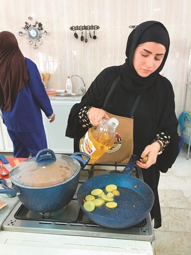 تركيز نسائي في إعداد طبق برياني الدجاج﻿