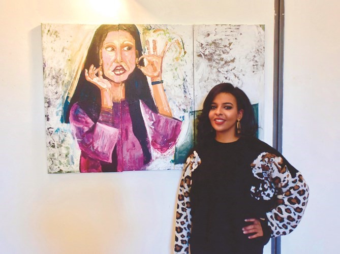 الفنانة الكويتية ريهام الرغيب بين بعض لوحاتها في معرض فنانات الكويت ضمن الأسبوع الثقافي الكويتي في إيطاليا ﻿