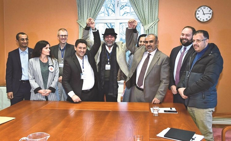 صورة تذكارية لممثلي الحكومة اليمنية والحوثيين مع اعضاء في مكتب المبعوث الأممي مارتن غريفيث والصليب الأحمر	 ( أ.ف.پ)﻿