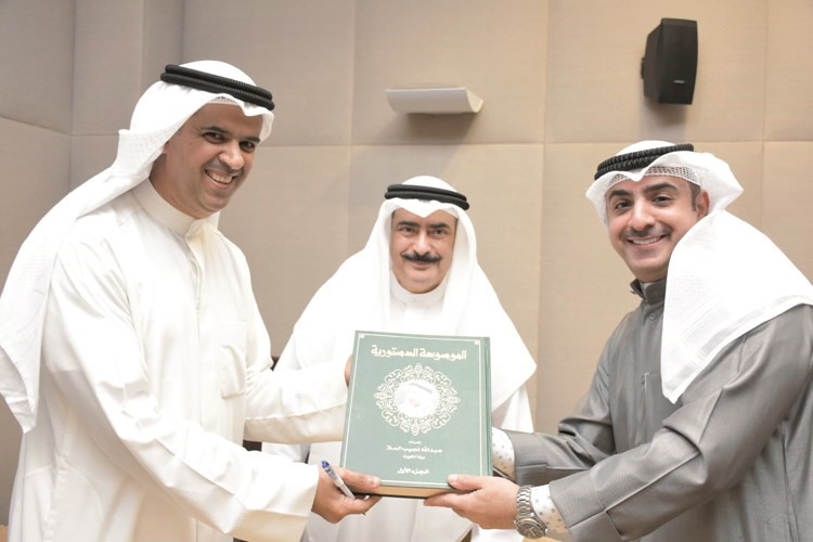 الملا يهدي الموسوعة الدستورية إلى أحد الحضور﻿