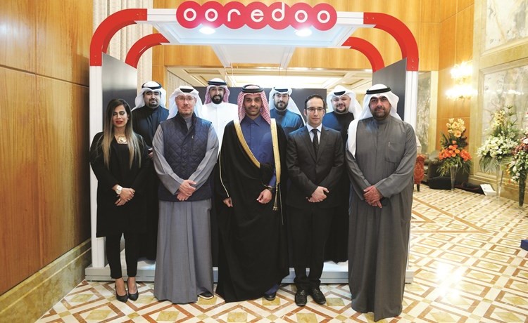 آل ثاني متوسطا فريق العمل أمام جناح الشركة خلال الحفل﻿