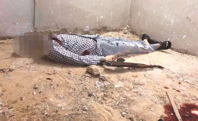 جثة احد الارهابيين بعد مقتله وفي الإطار احد الأحزمة الناسفة المضبوطة﻿