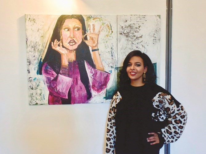 الفنانة ريهام الرغيب مع احدى لوحاتها﻿
