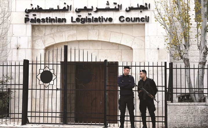 عنصران من الشرطة الفلسطينية يحرسان مبنى المجلس التشريعي في رام الله امس والذي اعلن عن حله مؤخرا	(ا.ف.پ) ﻿