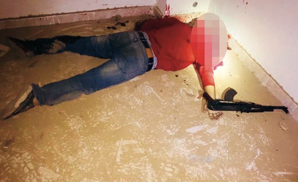جثة احد الارهابيين الذين تم القضاء عليهم وبيده بندقية آلية