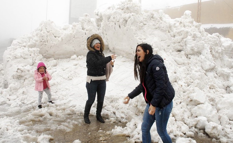 عائلة لبنانية خلال لعبها على الثلج في منطقة ضهر البيدر في جبل لبنان﻿