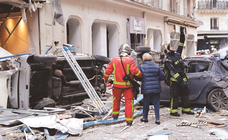 رجال الاطفاء يجلون امرأة من انفجار مخبز في وسط باريس امس	 (أ.ف.پ)﻿