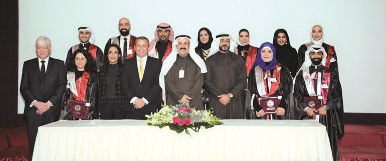 يعقوب الرفاعي وديسموند نيلسون مع موظفي البنك الأهلي الكويتي ﻿