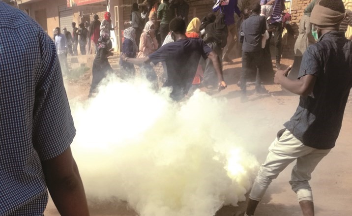 سودانيون يحاولون تجنب قنابل الغاز المسيل للدموع التي اطلقتها الشرطة لمنعهم من الوصول للقصر الرئاسي في الخرطوم امس(ا.ف.پ) ﻿