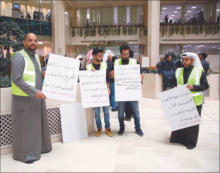 عدد من موظفي «الكهرباء» يحملون لافتات بمطالبهم خلال الاعتصام     (زين علام)