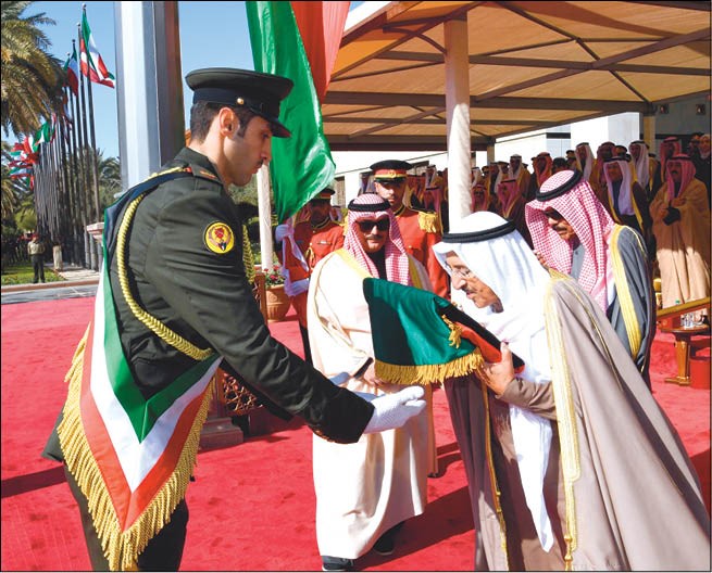 صاحب السمو الأمير الشيخ صباح الأحمد يقبّل علم الكويت خلال مراسم الاحتفال برفع العلم