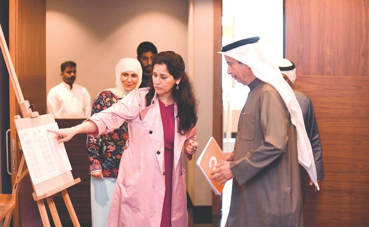 الشيخة انتصار سالم العلي ود.يوسف الإبراهيم يطلعان على جدول محاضرات البرنامج وتبدو رقية حسين﻿