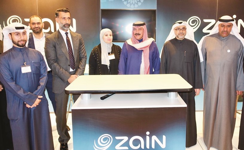 الدوسري يتوسط مشعل محمد وفريق زين في جناح الشركة ﻿