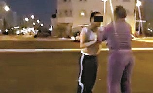 جانب من المقطع وتبدو الوافدة وقد كادت ان تنزع ملابس شخص في الشارع العام﻿