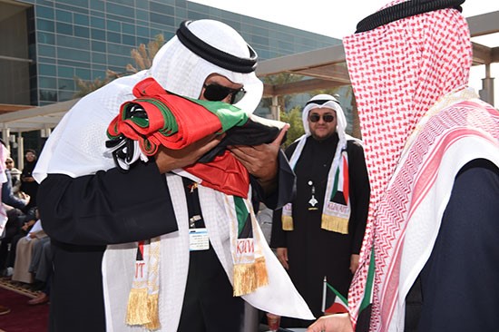 مدير عام الهيئة د. علي المضف مقبلا علم الكويت