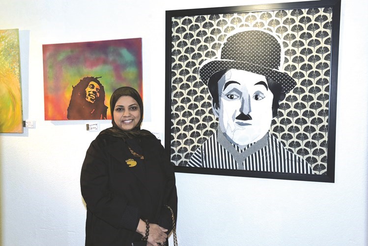 الفنانة التشكيلية سهيلة العطية أمام إحدى لوحاتها﻿