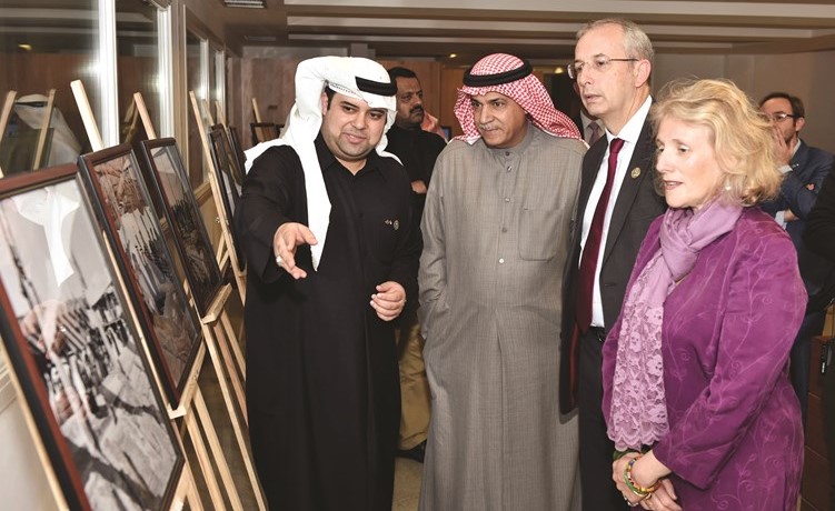 م.علي اليوحة والسفير مايكل دافنبورت يستمعان لشرح من د. عيسى دشتي حول الصور المعروضة بالمعرض ﻿