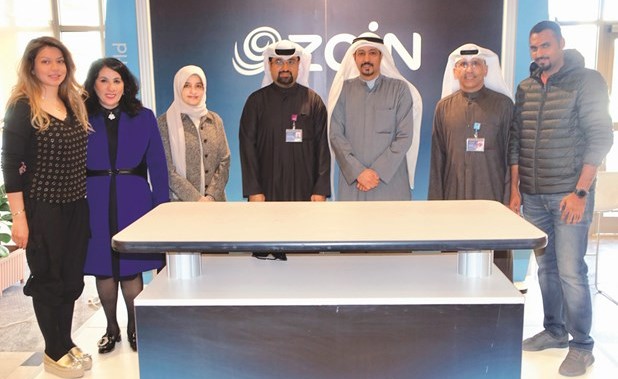 المطيري يتوسط مسؤولي زين في جناح الشركة بالمعرض ﻿