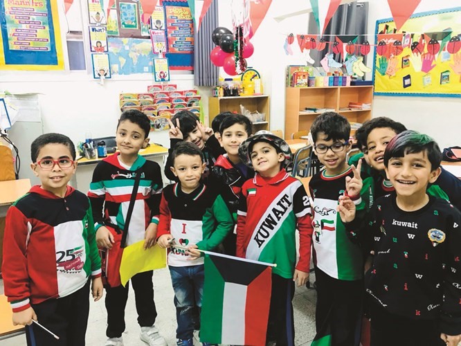 الأطفال يحملون علم الكويت﻿