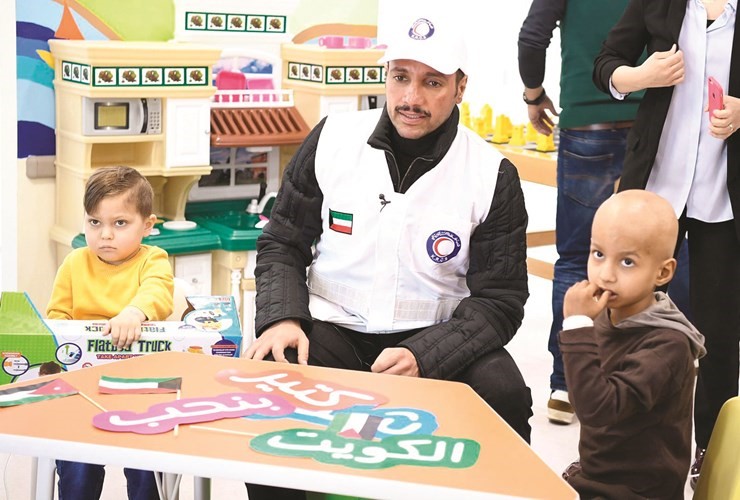رئيس مجلس الأمة مرزوق الغانم متوسطا بعض الأطفال خلال زيارته إلى مركز الحسين للسرطان ﻿