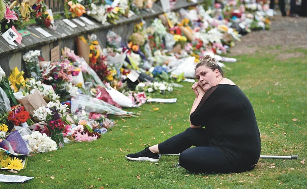  نيوزيلندية تبكي أمام الزهور الموضوعة على مدخل مستشفى كرايست تشرش تضامنا مع ضحايا الهجوم        (ا.ف.پ)