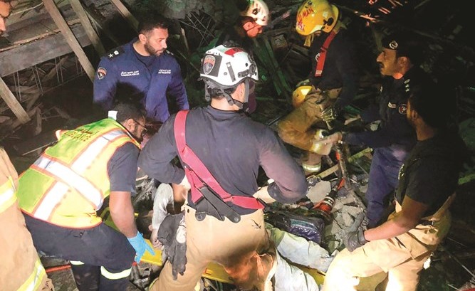 رجال الإطفاء يحاولون إنقاذ أحد العمال عقب انهيار السقف﻿