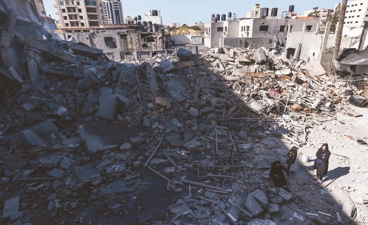 فلسطينيون يتفقدون ركام منازلهم التي هدمتها غارات الاحتلال على غزة امس الاول(ا.ف.پ) ﻿