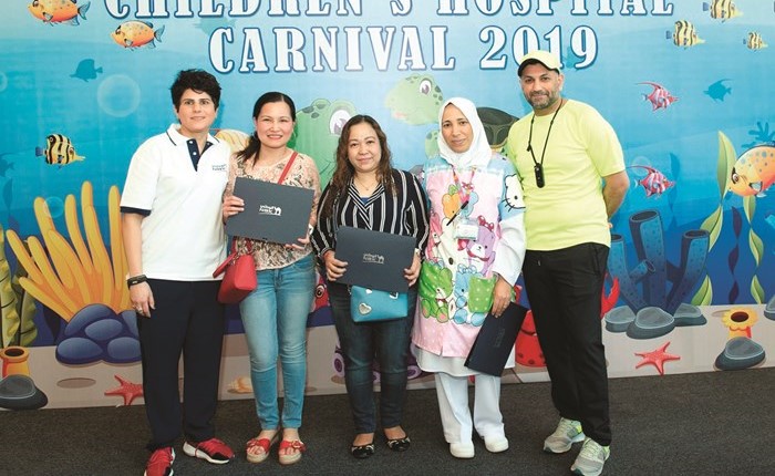 منال المطر ود.ميثم حسين في لقطة جمعتهم مع أسر بعض الأطفال المشاركين في المهرجان﻿