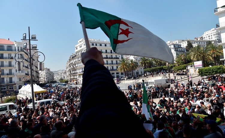  جزائريون يلوحون بعلم بلادهم خلال احتجاجات تطالب بتغيير جذري للنظام امس	( ا.ف.پ) ﻿