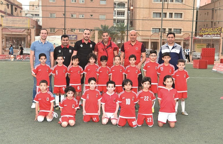 خالد بيبو ومعز عثمان مع عدد من لاعبي ومدربي أكاديمية النادي الأهلي بالكويت﻿
