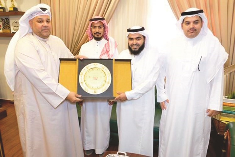 م.محمد الصايغ وحمد عسيري خلال تبادل الدروع التكريمية﻿