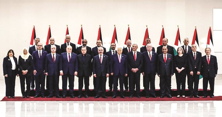 الرئيس الفلسطيني محمود عباس متوسطا أعضاء الحكومة الجديدة في الضفة الغربية امس الاول	 (أ.ف.پ)﻿