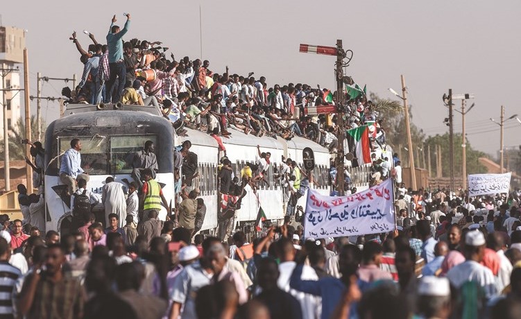 مئات السودانيين القادمين على قطار من مدينة عطبرة للانضمام الى المعتصمين في الخرطوم (أ.ف.پ) ﻿