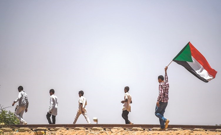 محتجون سودانيون يحملون علم بلادهم خلال مشاركتهم في الاعتصام امام مقر المجلس العسكري امس	(أ.ف.پ)﻿