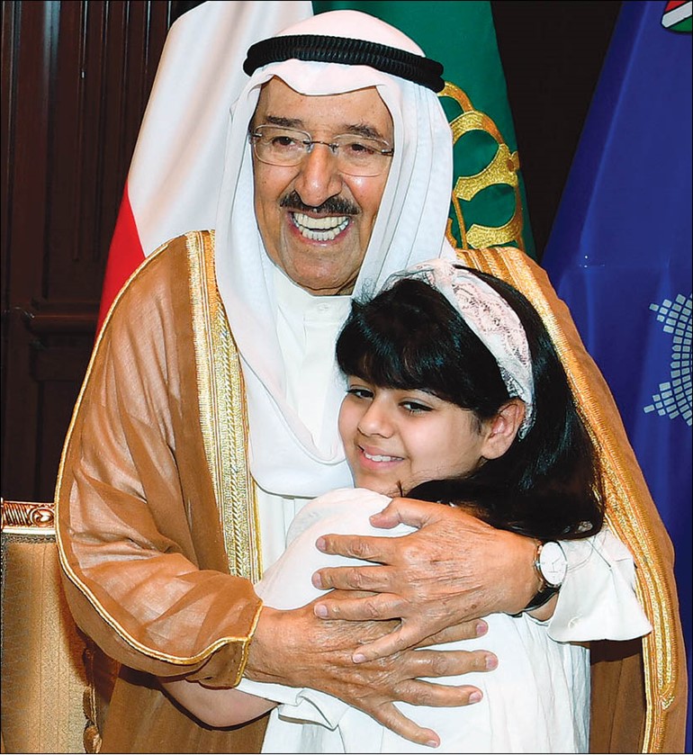 صاحب السمو الأمير الشيخ صباح الأحمد محتضنا ابنة شهيد الواجب وكيل عريف خالد ناصر الواوان	
