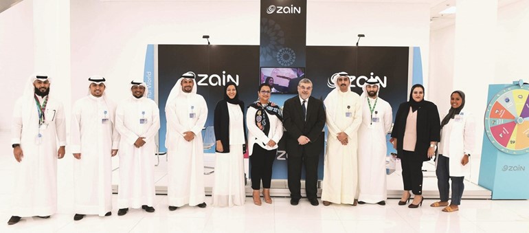 نوال بورسلي تتوسط فريق زين في جناح الشركة بالمعرض﻿